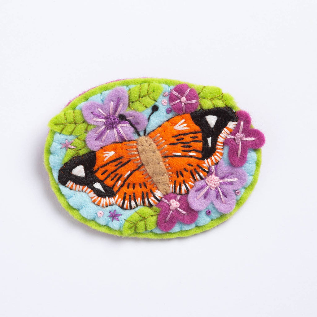 Decorative brooch with a butterfly and flowers on a white background