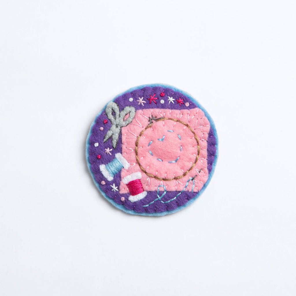Circular patch with a pink center and purple border on a white background